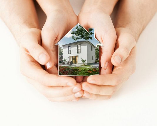 sicherheit-schutz-geborgenheit-familie-haus-geschuetzt-02 Schützende Hände um ein illustriertes Haus.